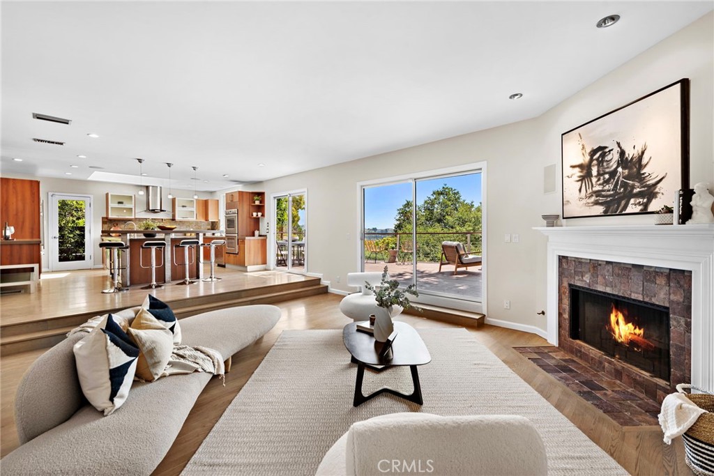 a living room with furniture a fireplace and a large window