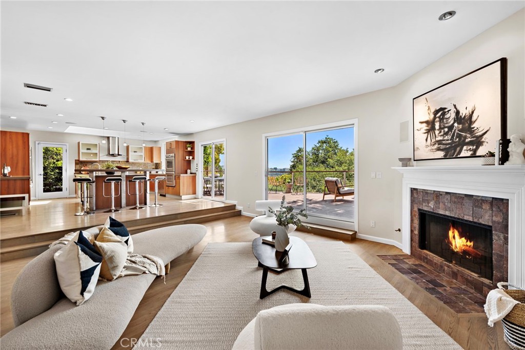 a living room with furniture a fireplace and a large window