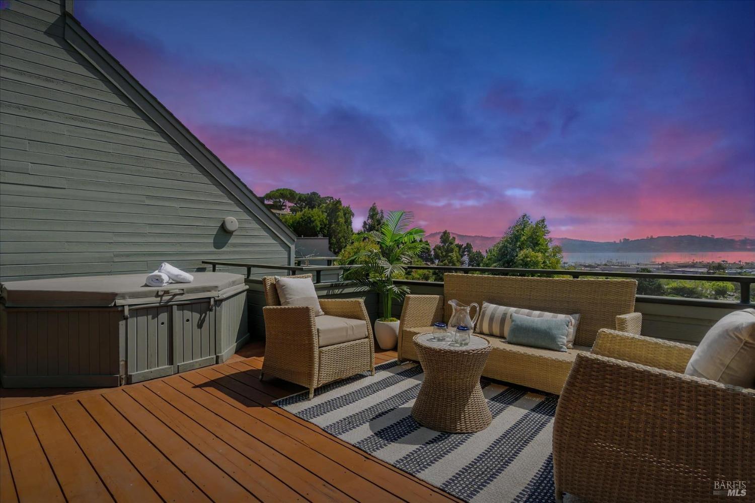 a view of a roof deck with couches and sky view