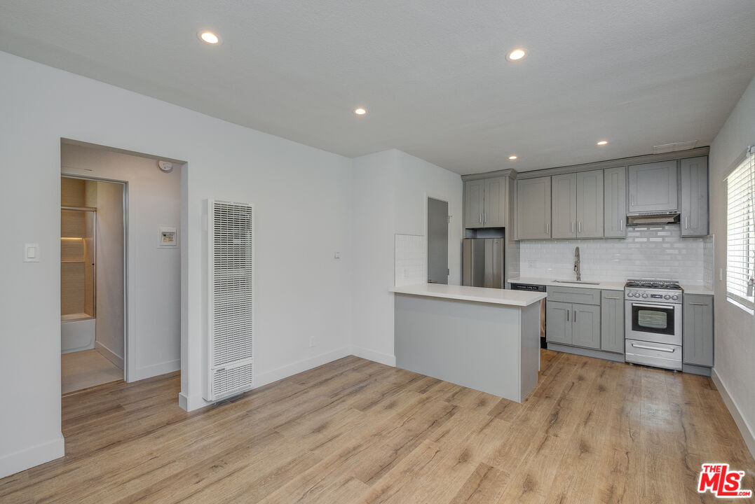 a kitchen with granite countertop a stove top oven and cabinets