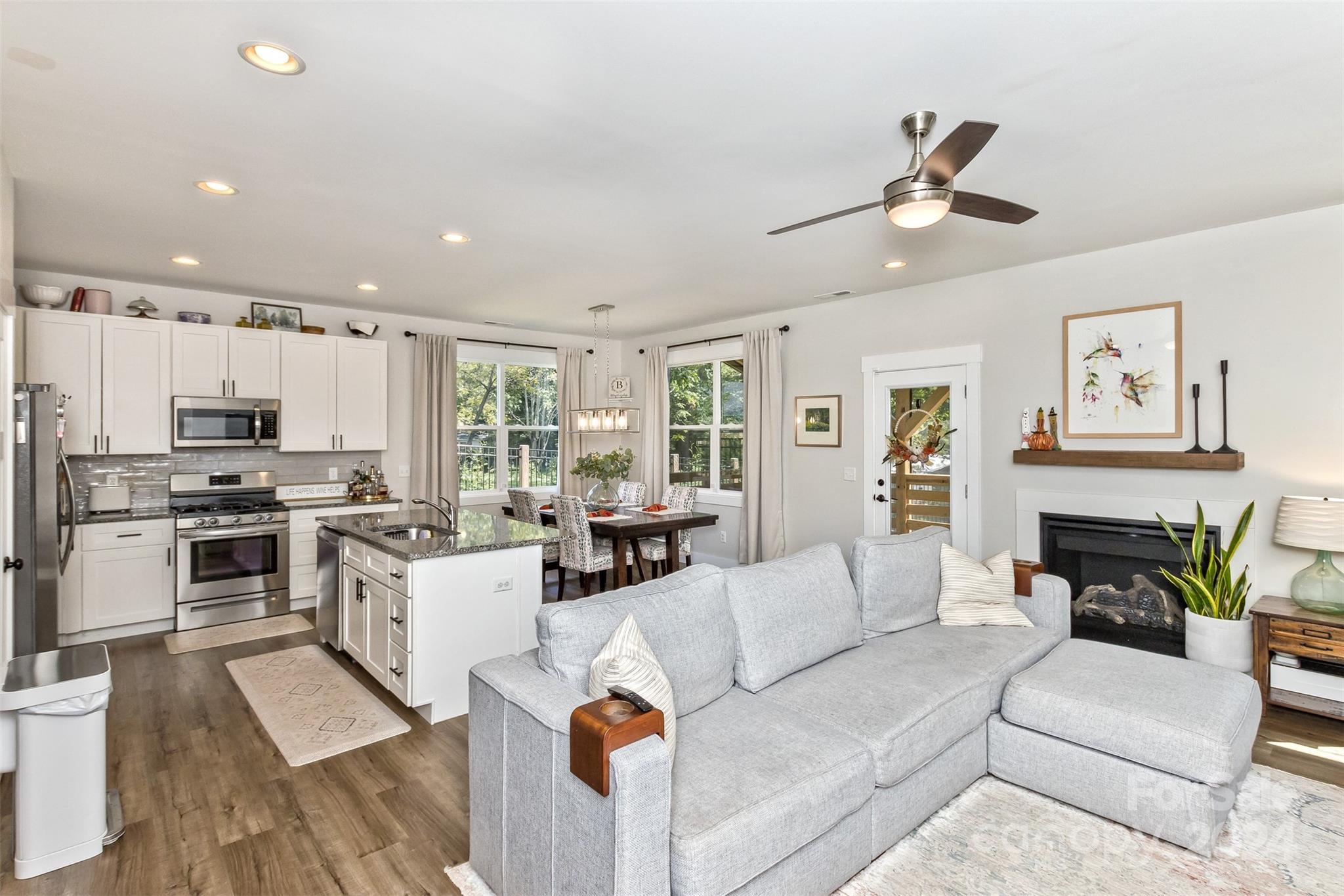 a living room with furniture appliances and kitchen view