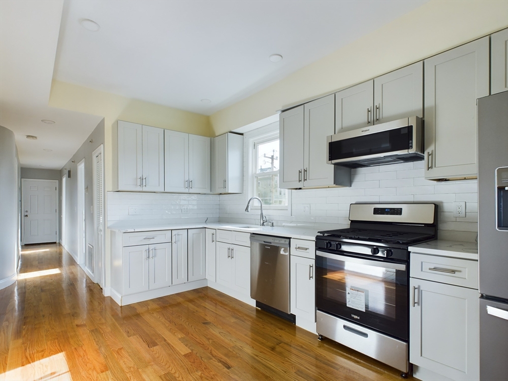 a kitchen with granite countertop a sink and steel appliances