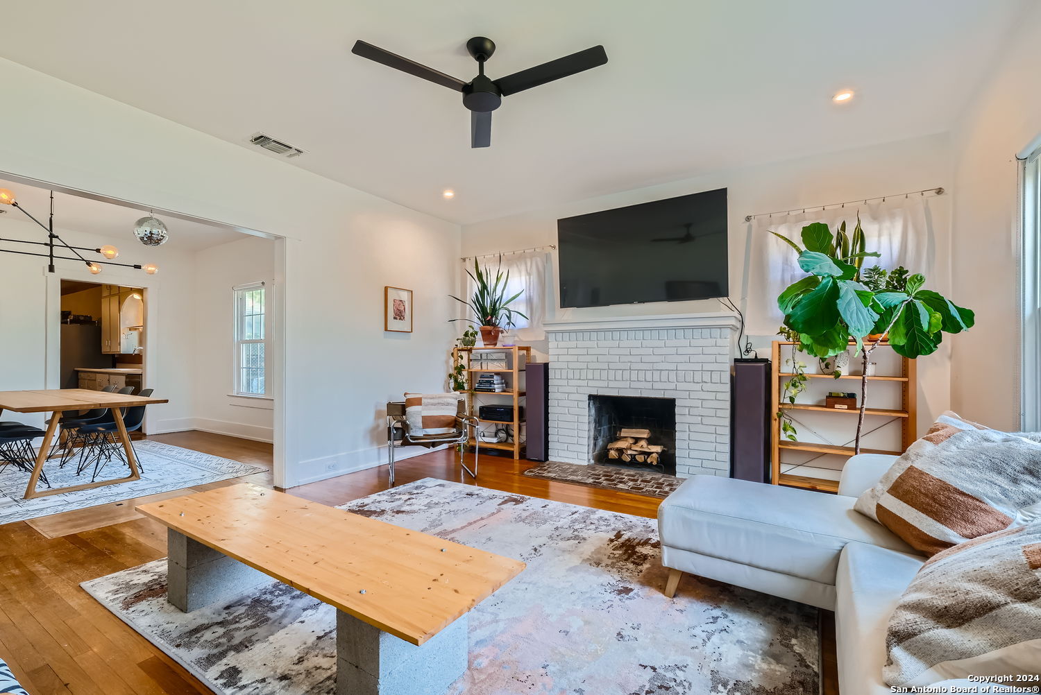 a living room with furniture a flat screen tv and a fireplace