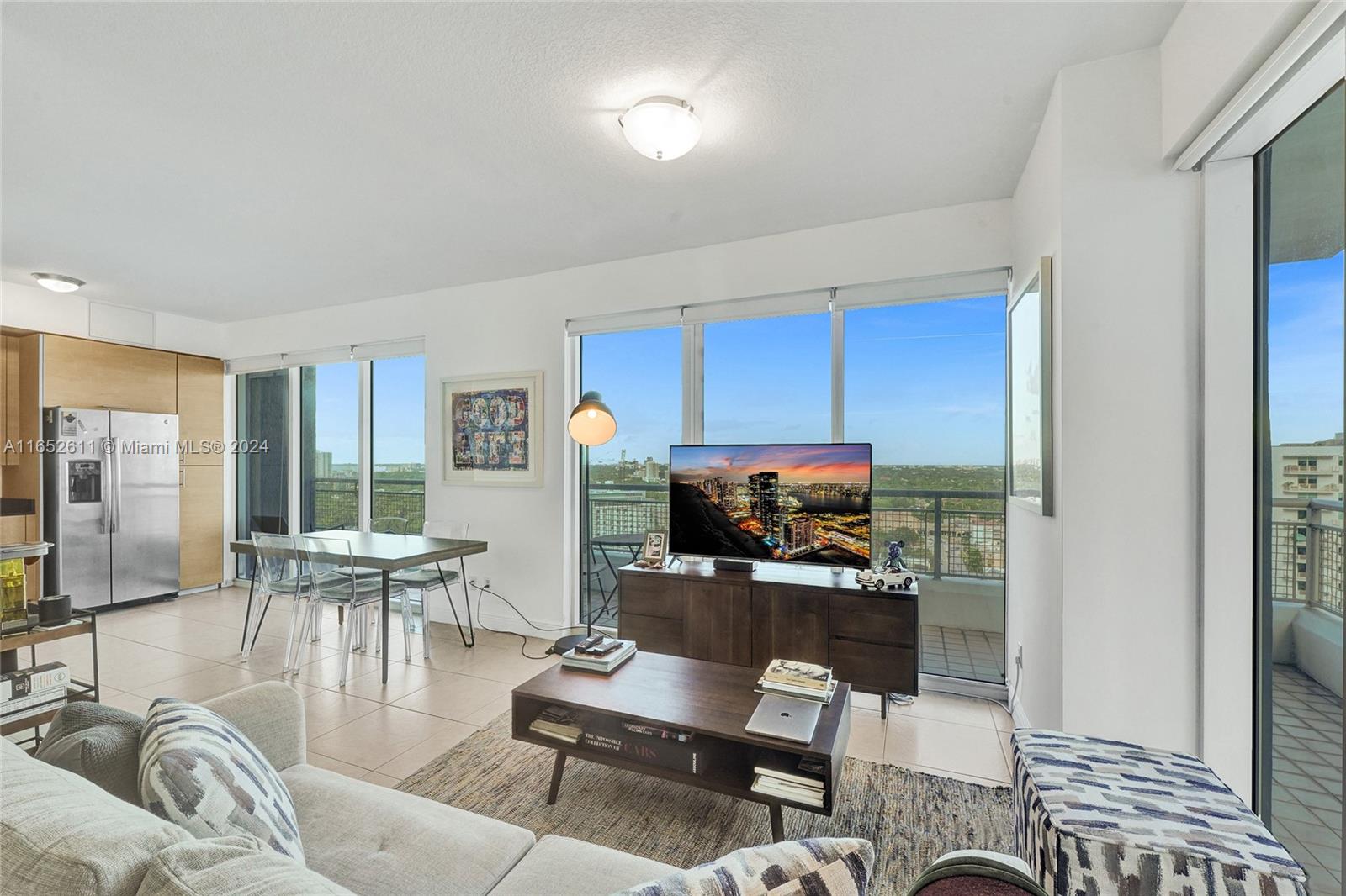 a living room with furniture a flat screen tv and a window