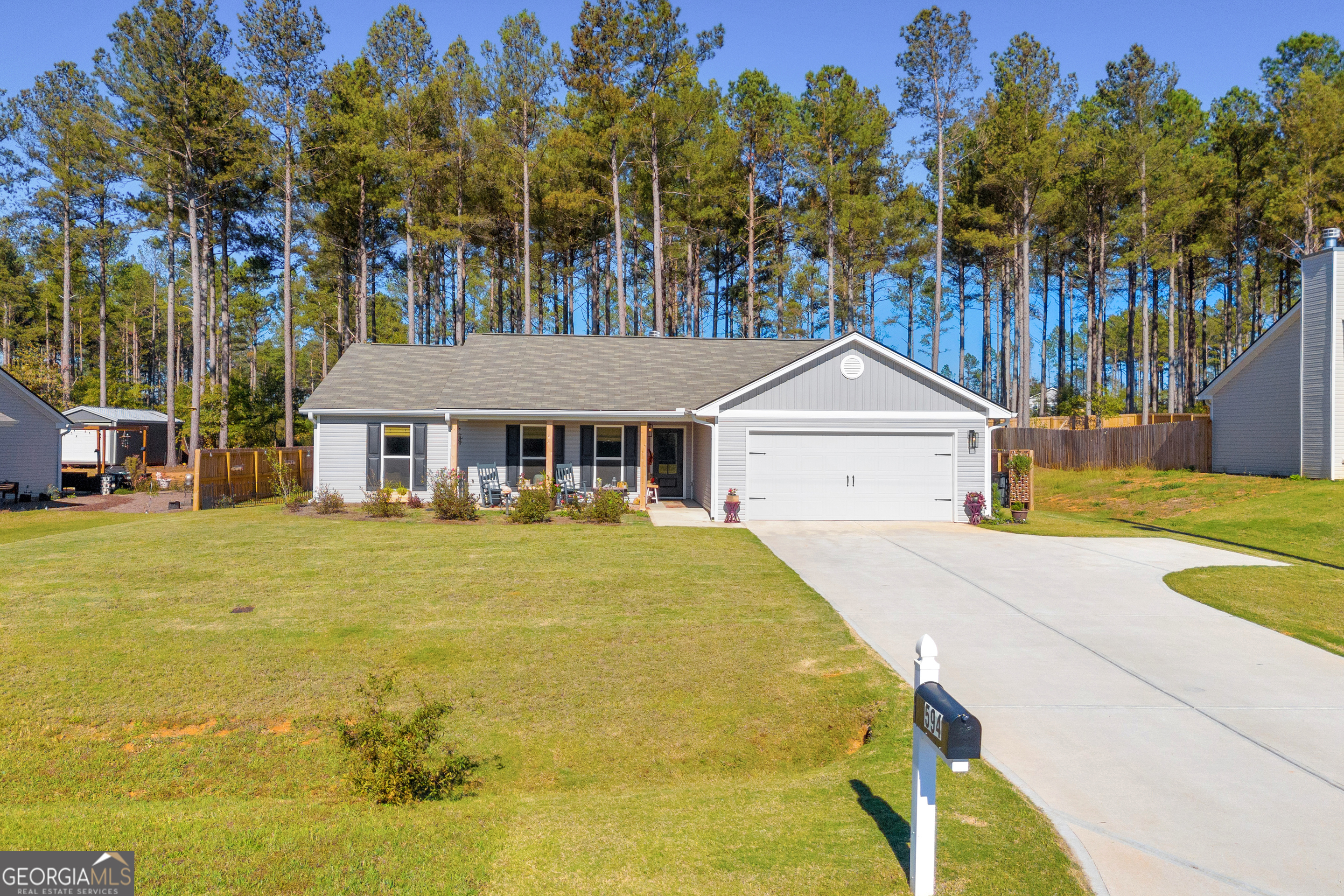 a front view of a house with yard and tree