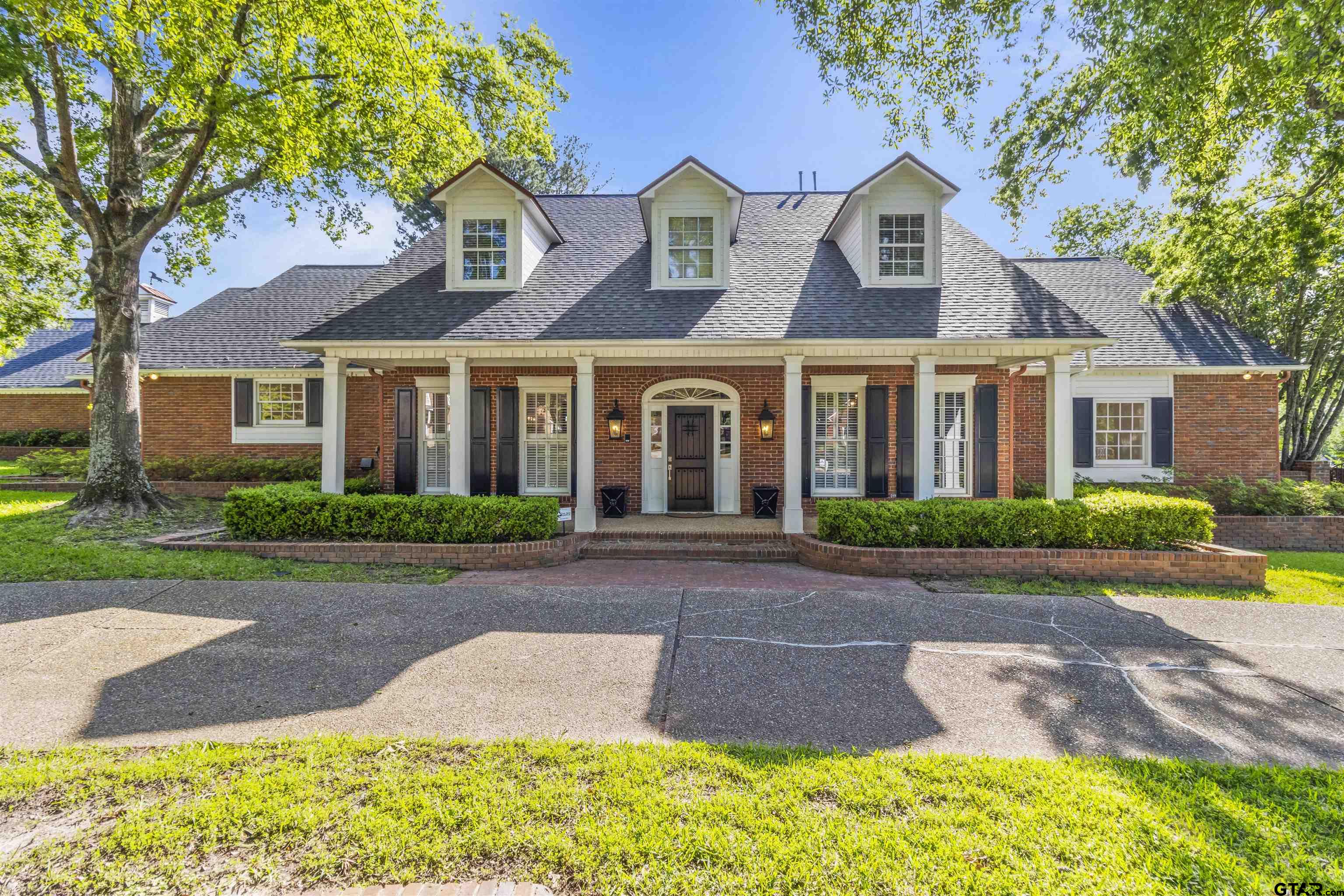 front view of a brick house with a yard