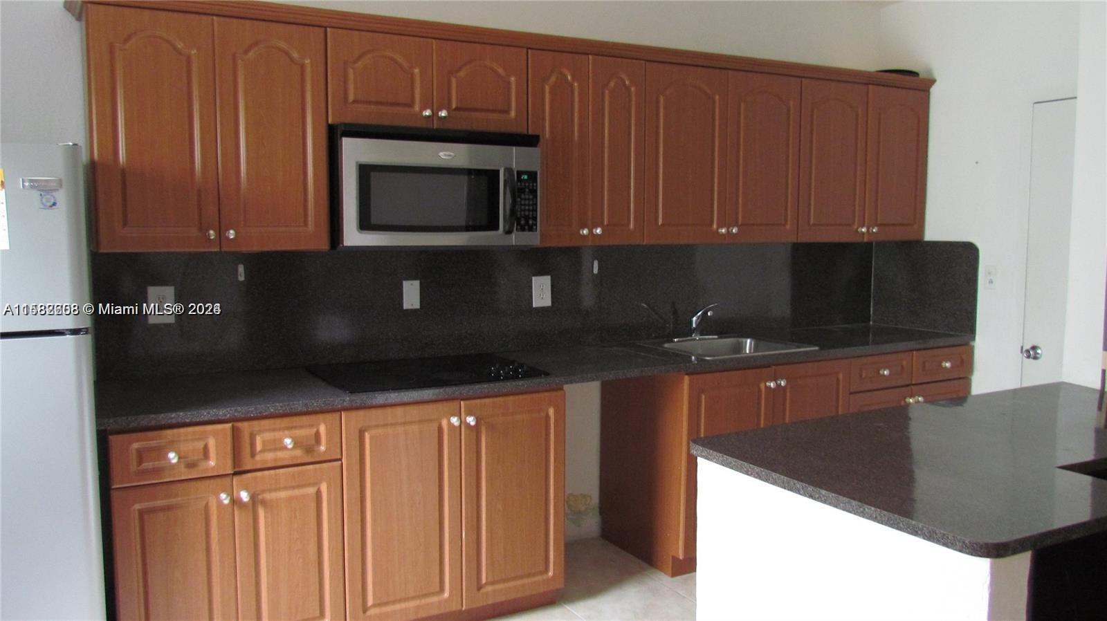 a kitchen with stainless steel appliances granite countertop a stove a microwave and a refrigerator