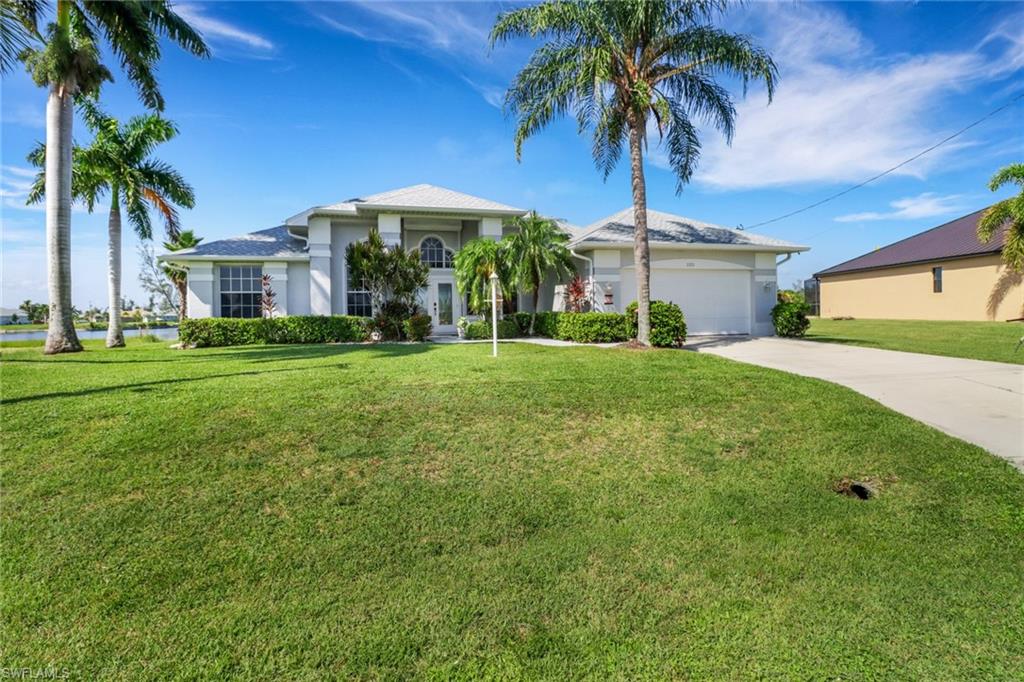 a view of a house with a yard and palm trees