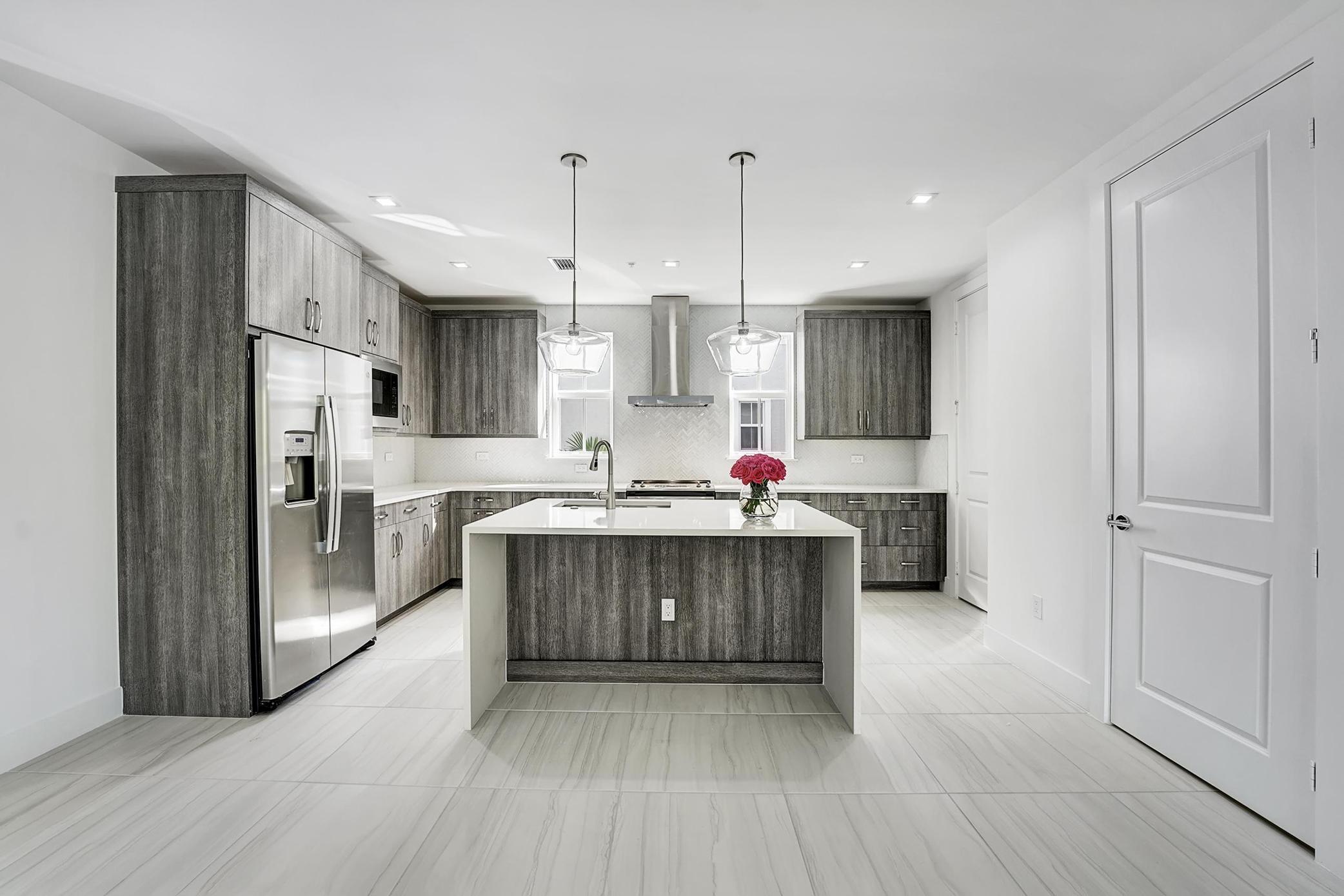 a kitchen with stainless steel appliances granite countertop a refrigerator and a sink