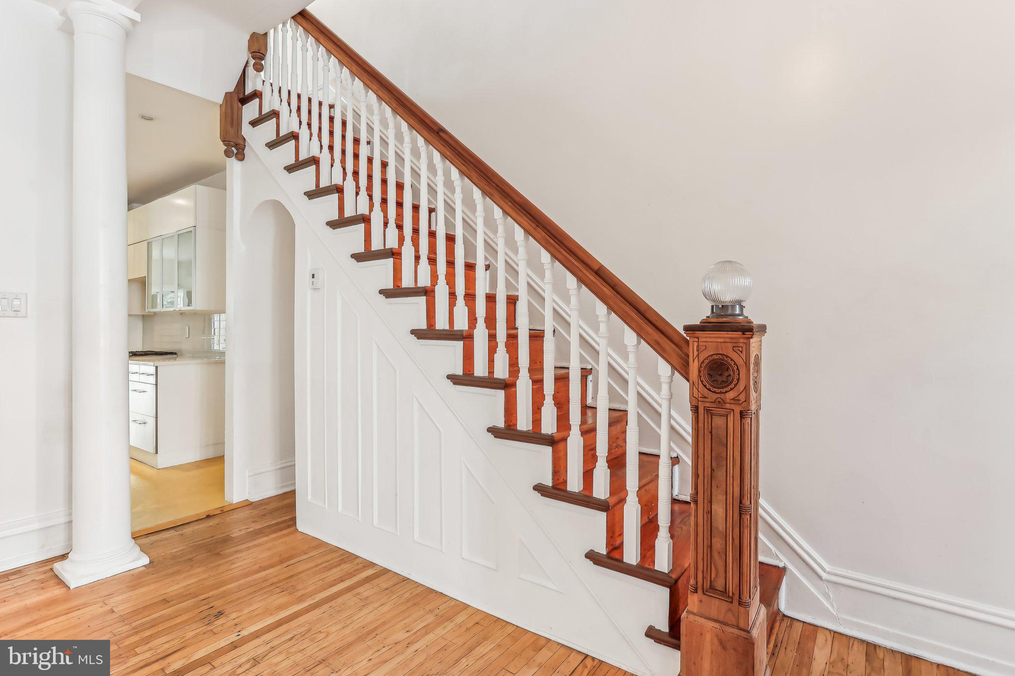 a view of staircase with wooden floor and white walls