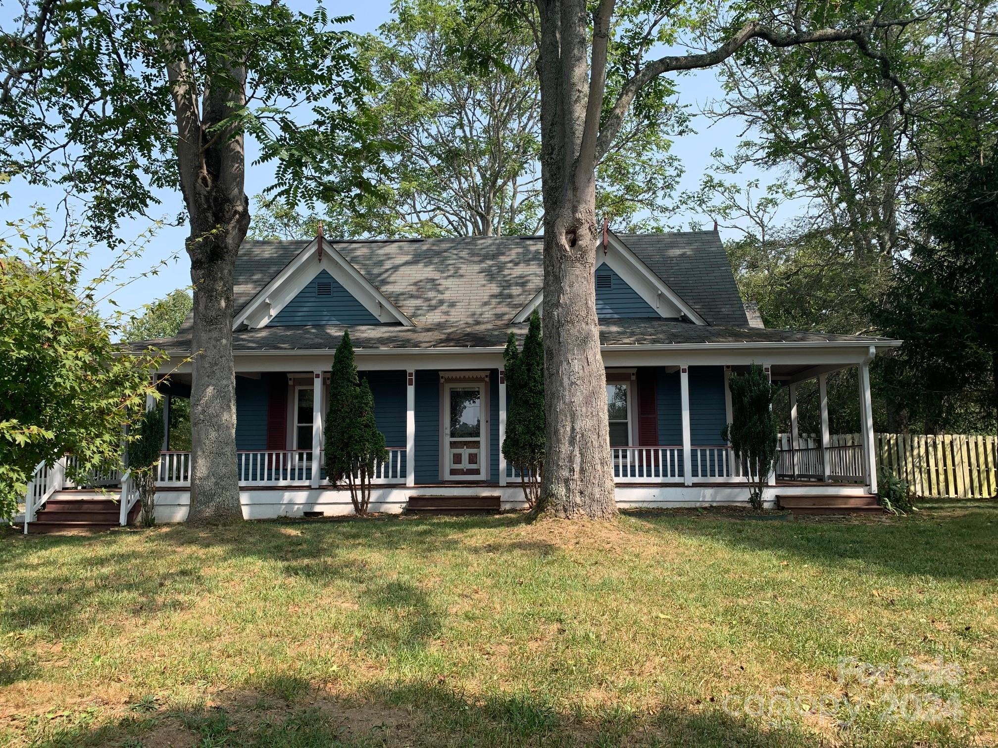 a front view of a house with a tree in it