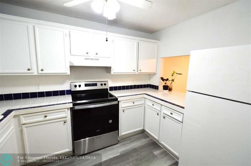 a kitchen with white cabinets and white appliances