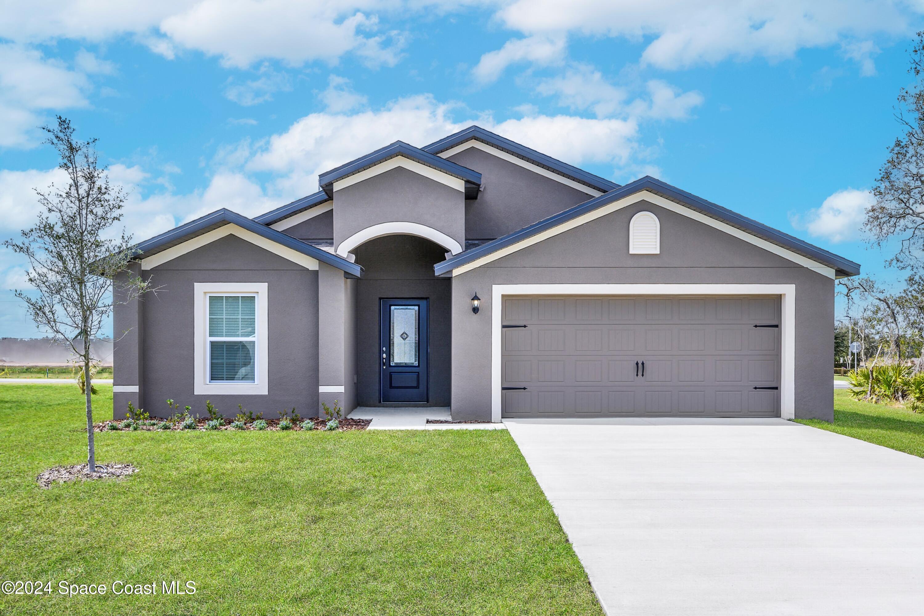 a front view of a house with a yard and garage