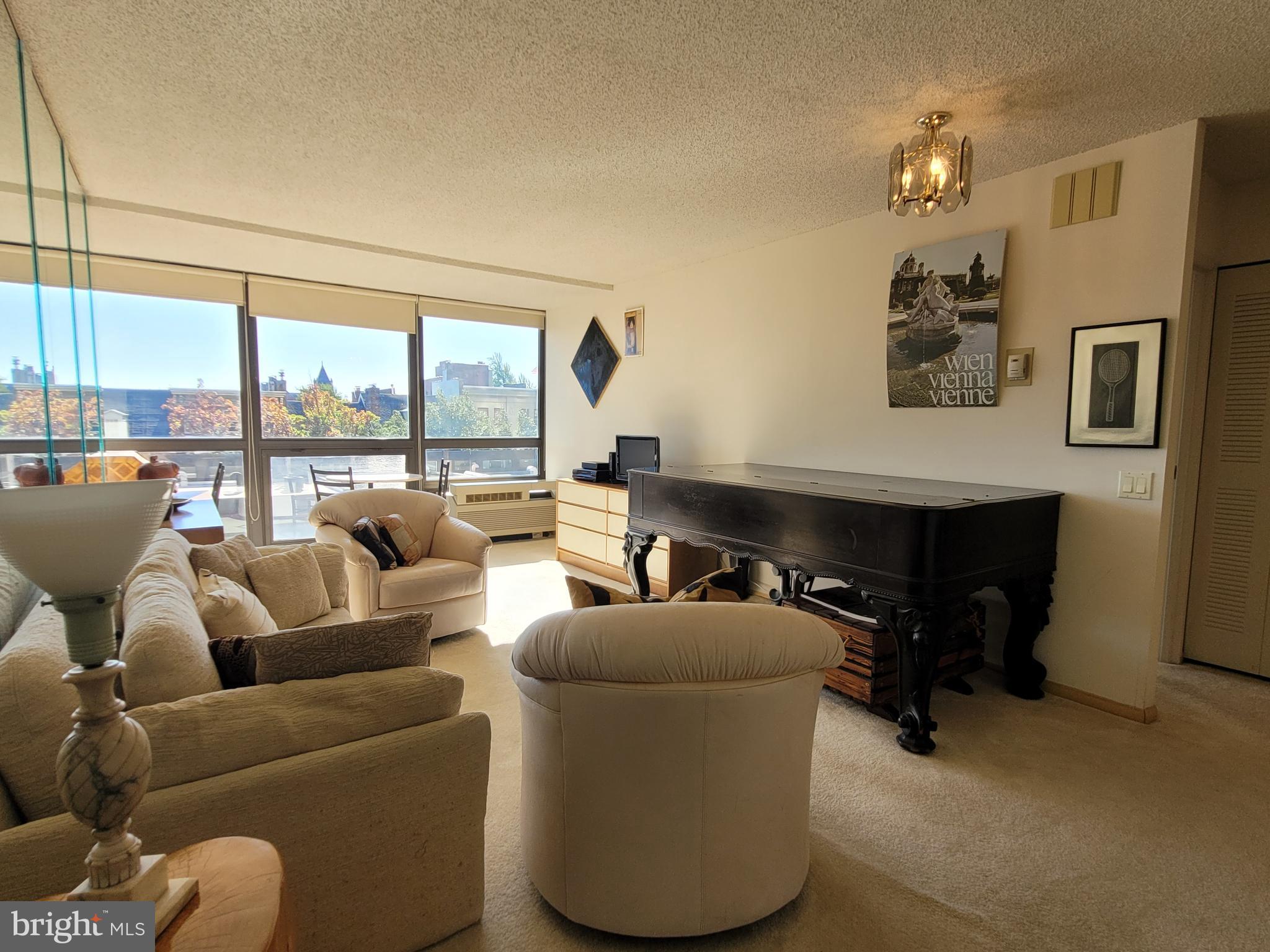 a living room with furniture and a floor to ceiling window