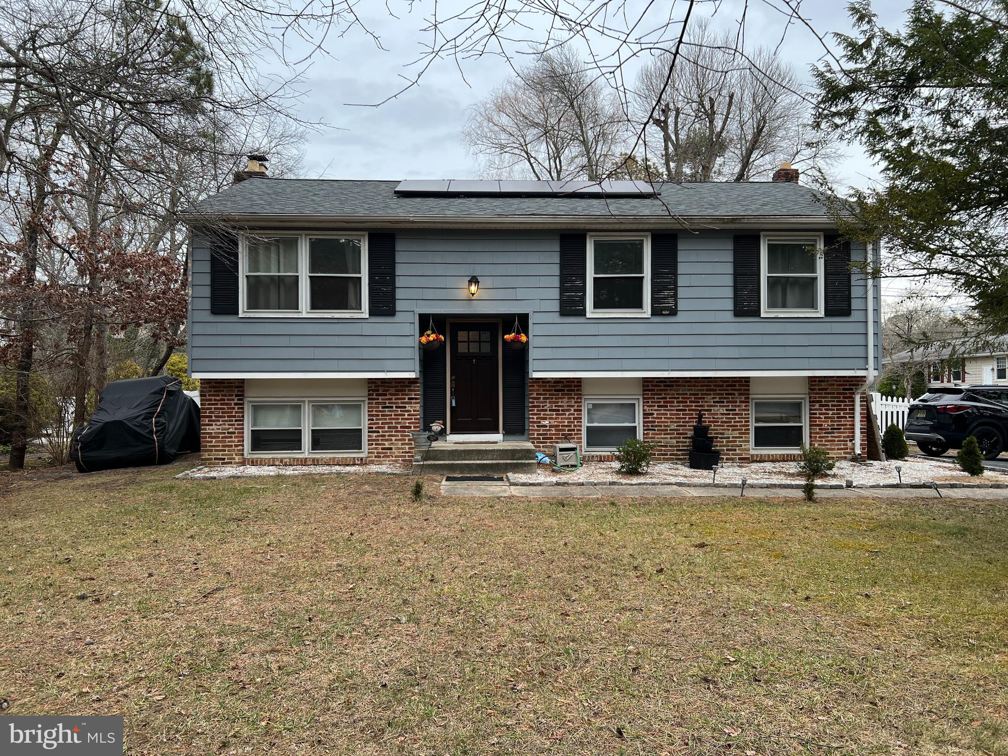 a front view of a house with yard and trees