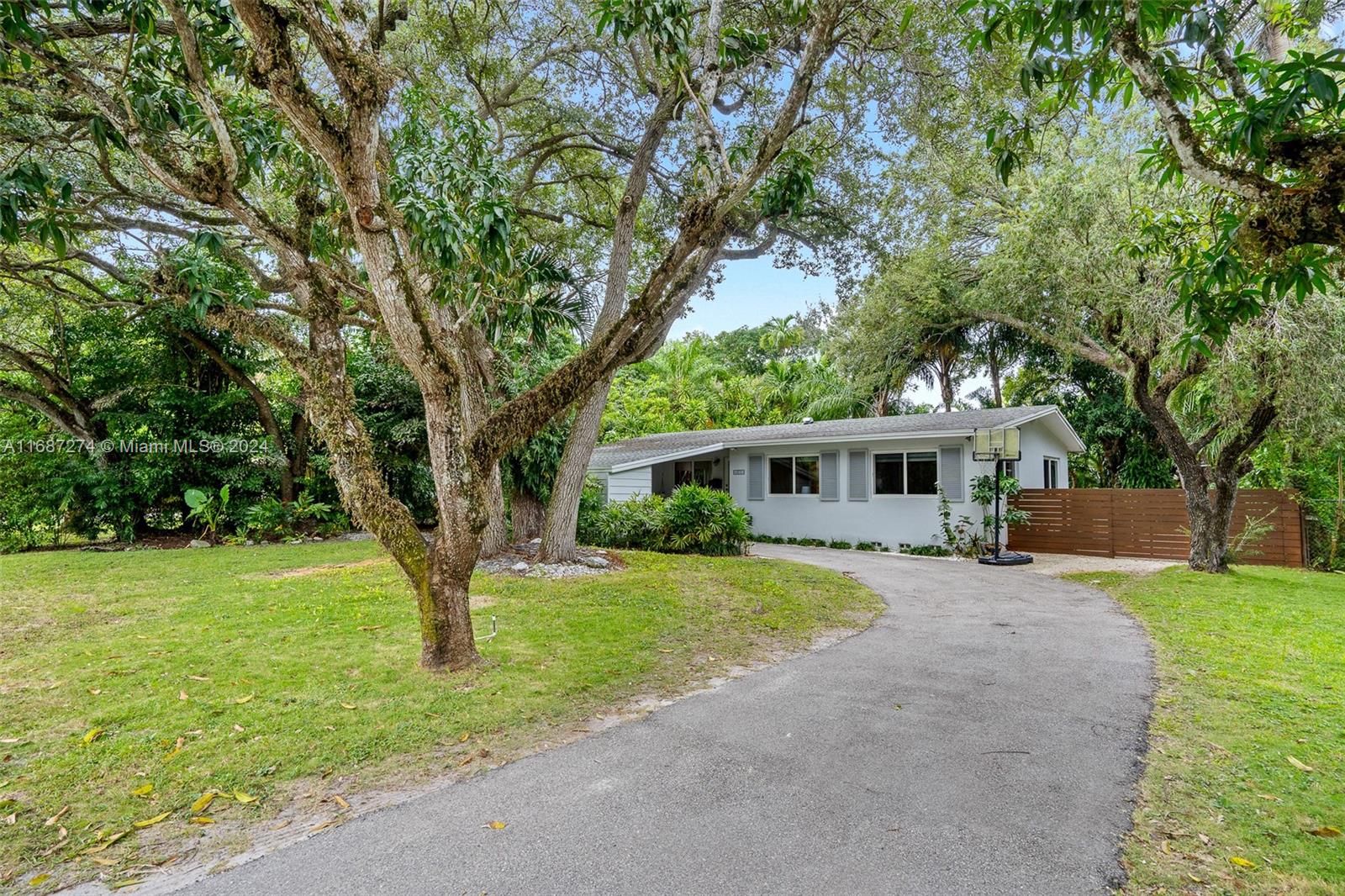 a front view of a house with a yard and trees