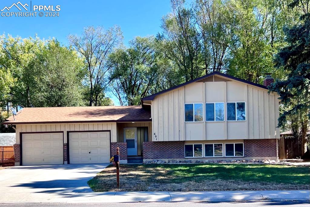 Bi-level home featuring a front yard and a garage