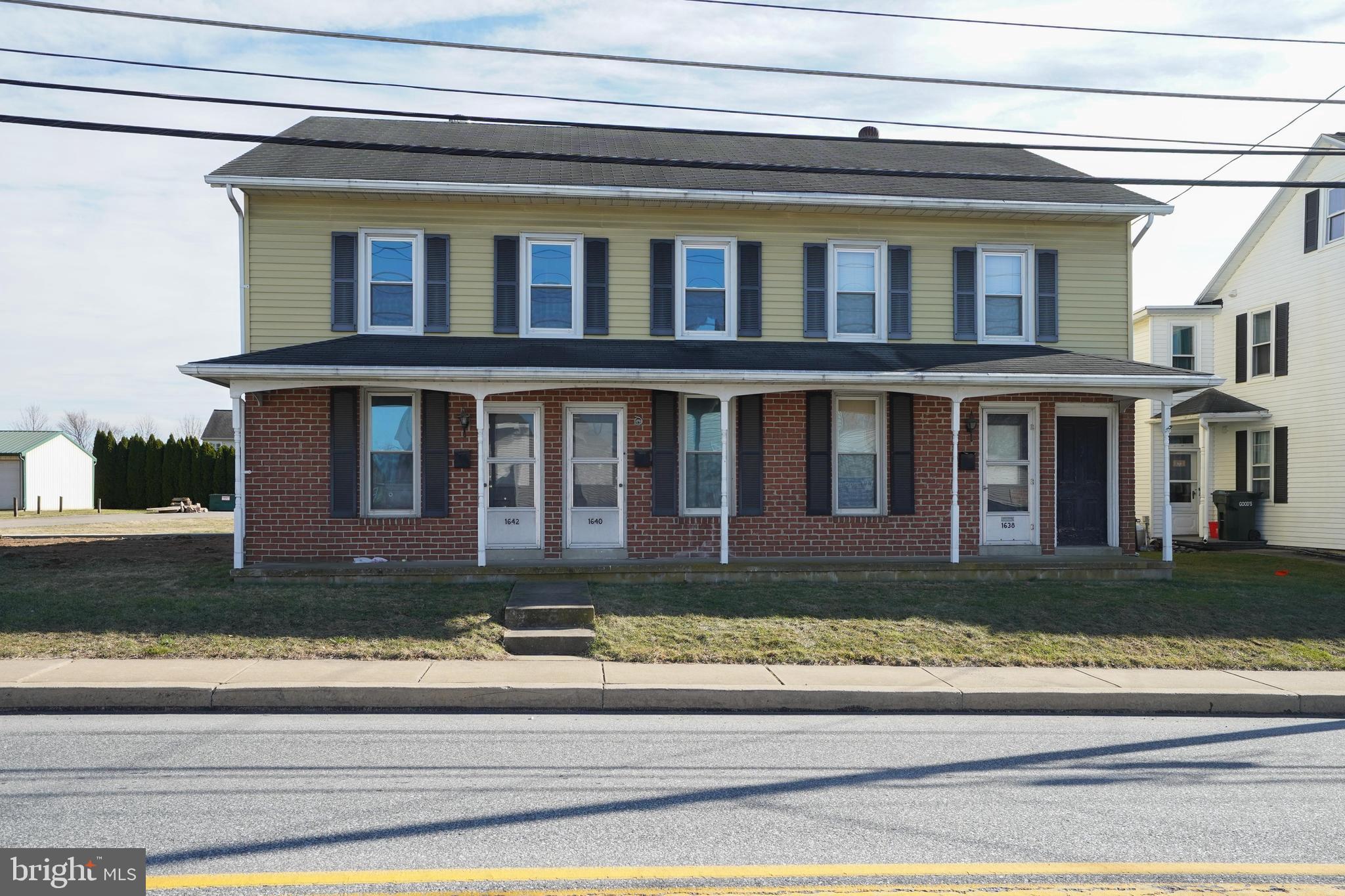 a view of a brick house next to a yard