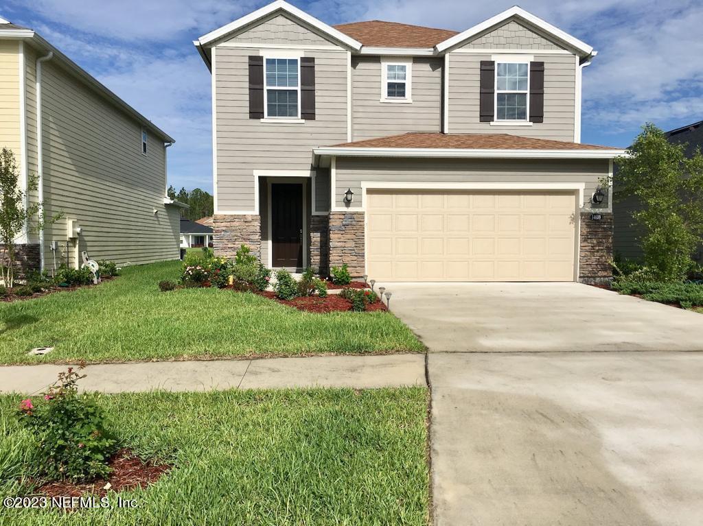 a front view of a house with a yard and garage