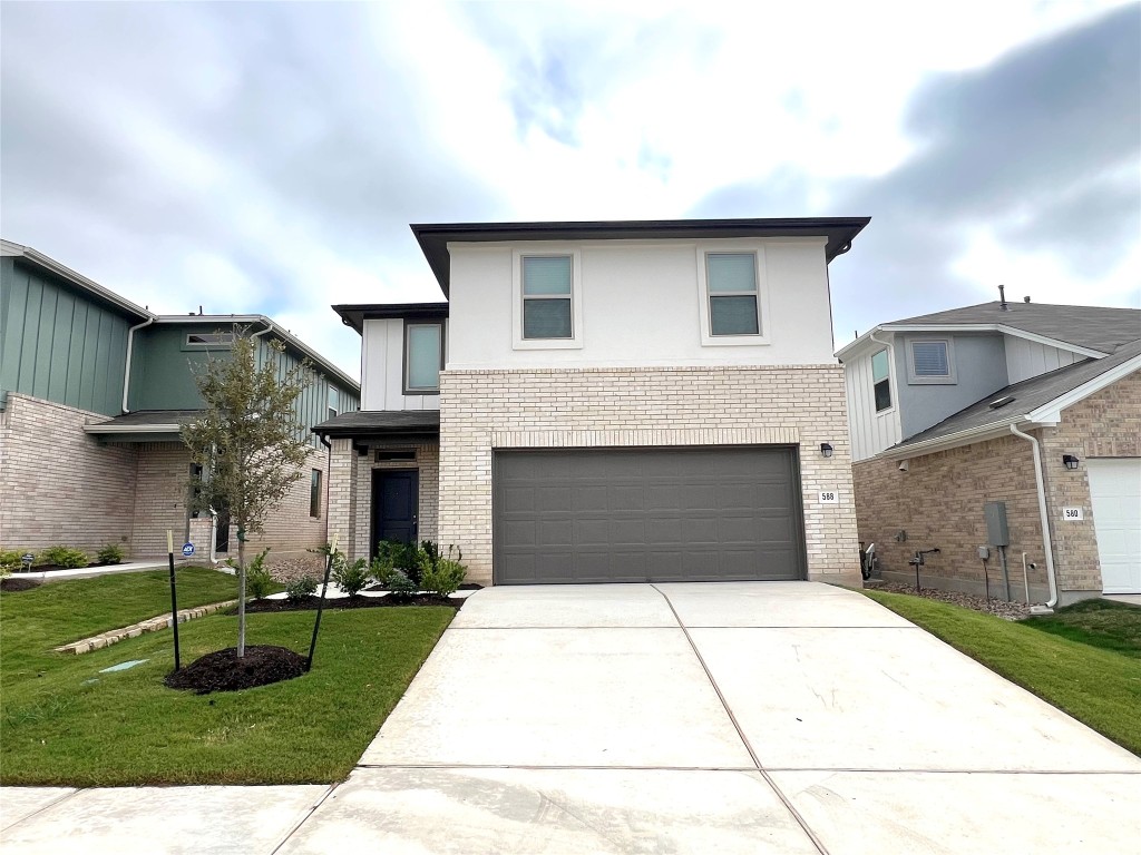 a front view of a house with a yard and garage