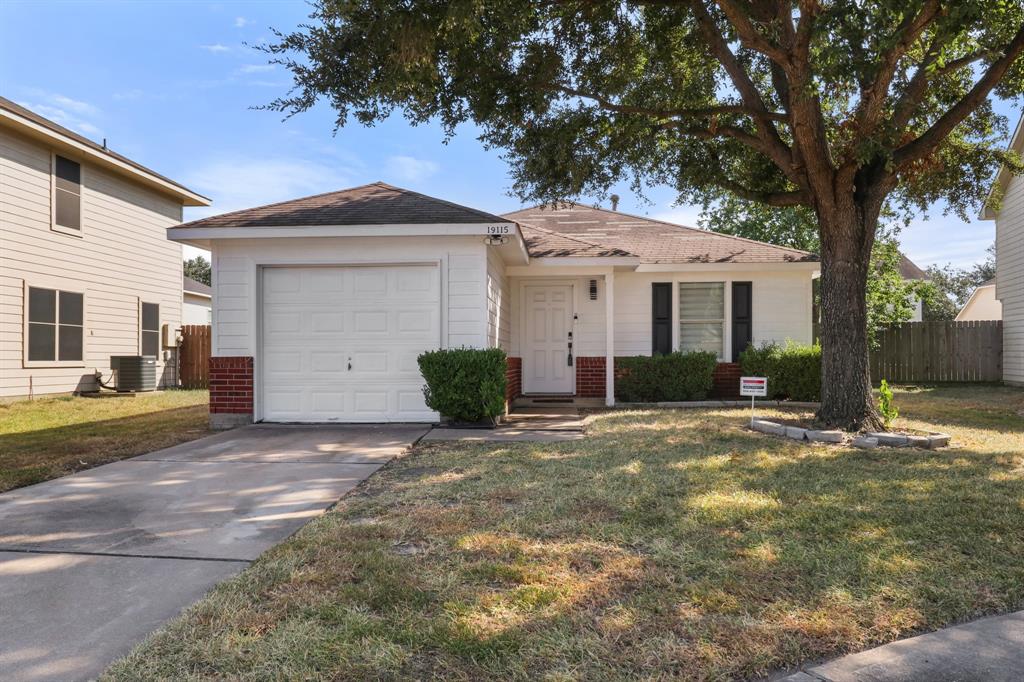 a view of a house with a yard and large tree