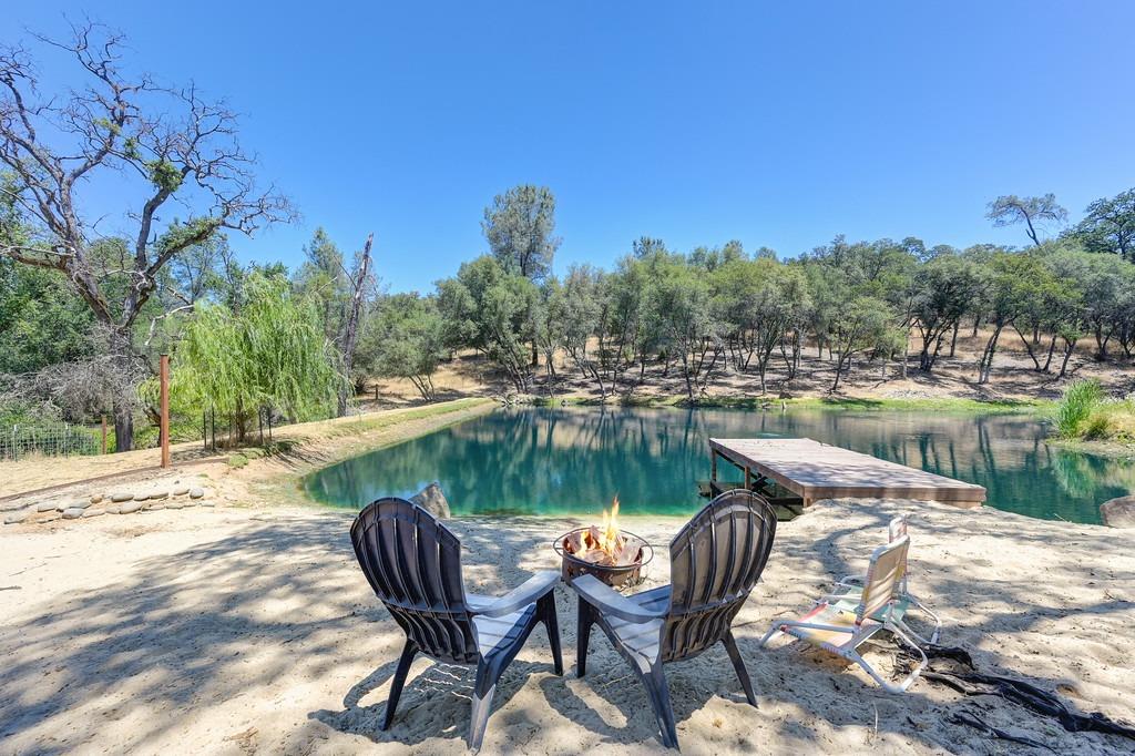 a view of a lake with table and chairs