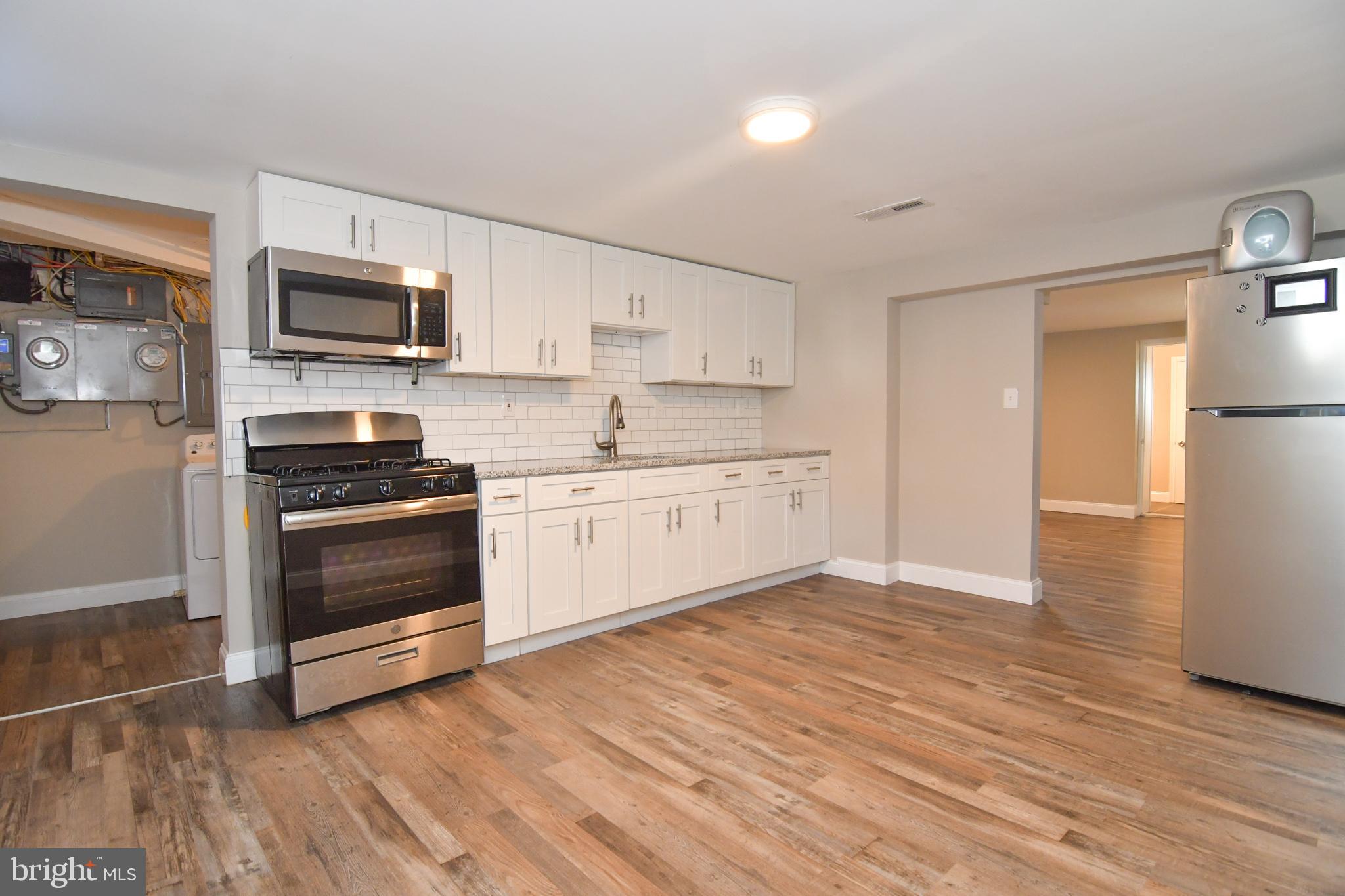 a kitchen with stainless steel appliances a stove a microwave and white cabinets