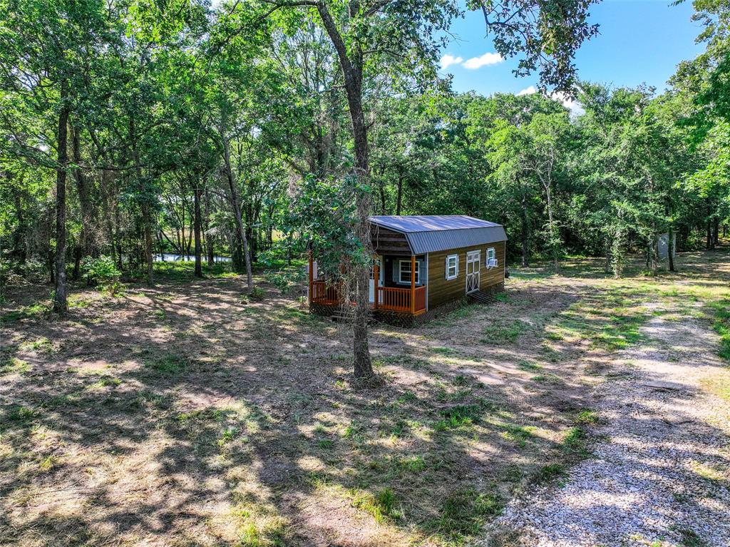 a view of a house with backyard and a tree