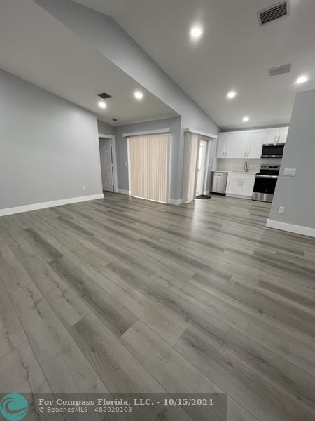 a view of empty room with wooden floor