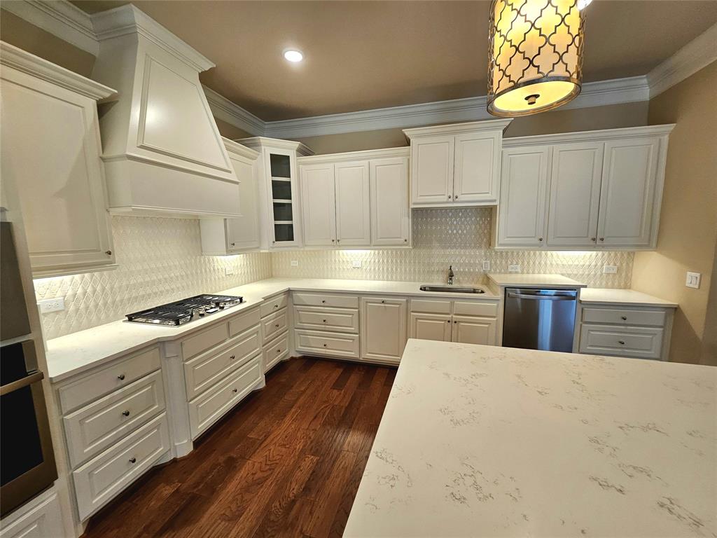 a kitchen with stainless steel appliances a stove a sink and a refrigerator