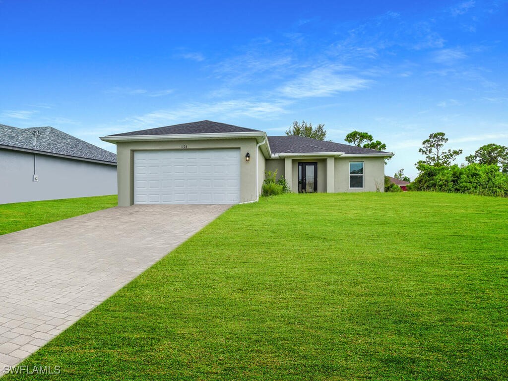 a front view of a house with a yard and garage