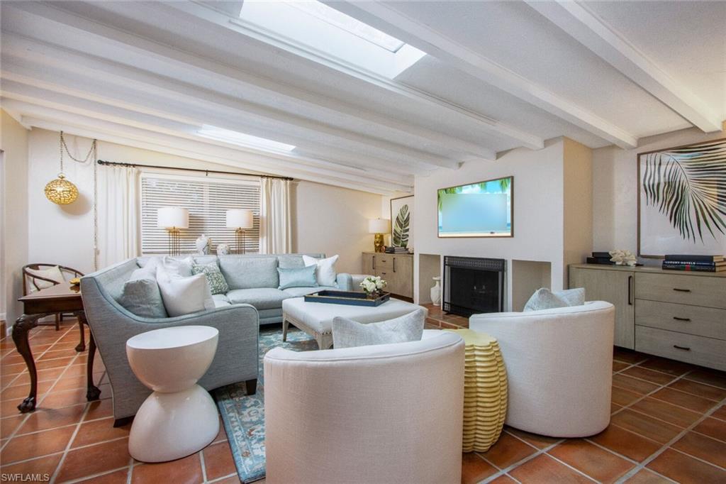 Living room featuring beam ceiling and dark tile patterned floors