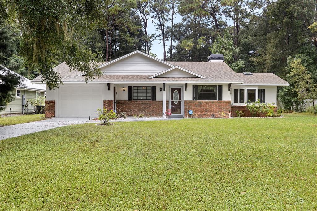 a front view of a house with a yard and trees