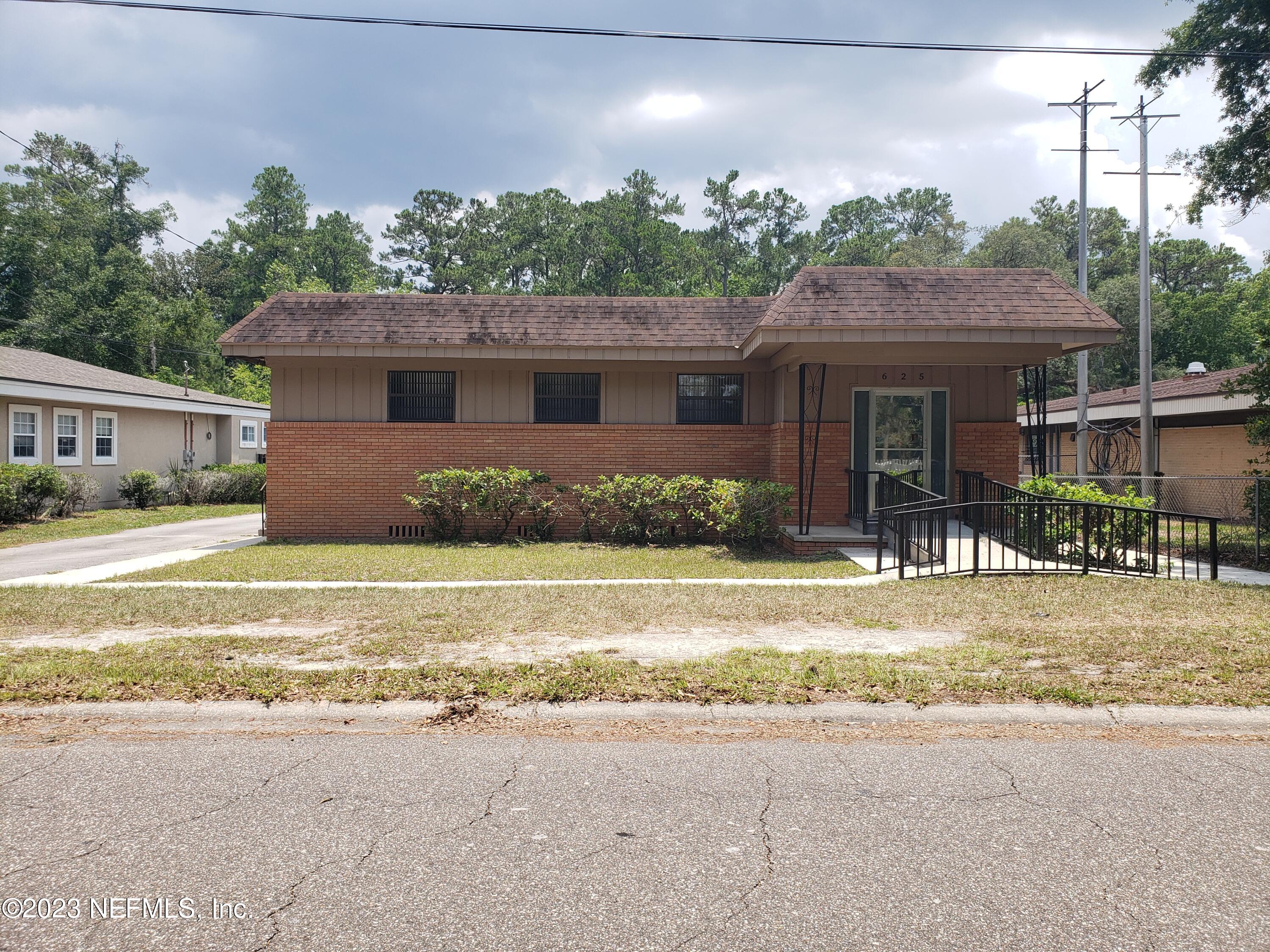 a front view of a house with a yard and potted plants