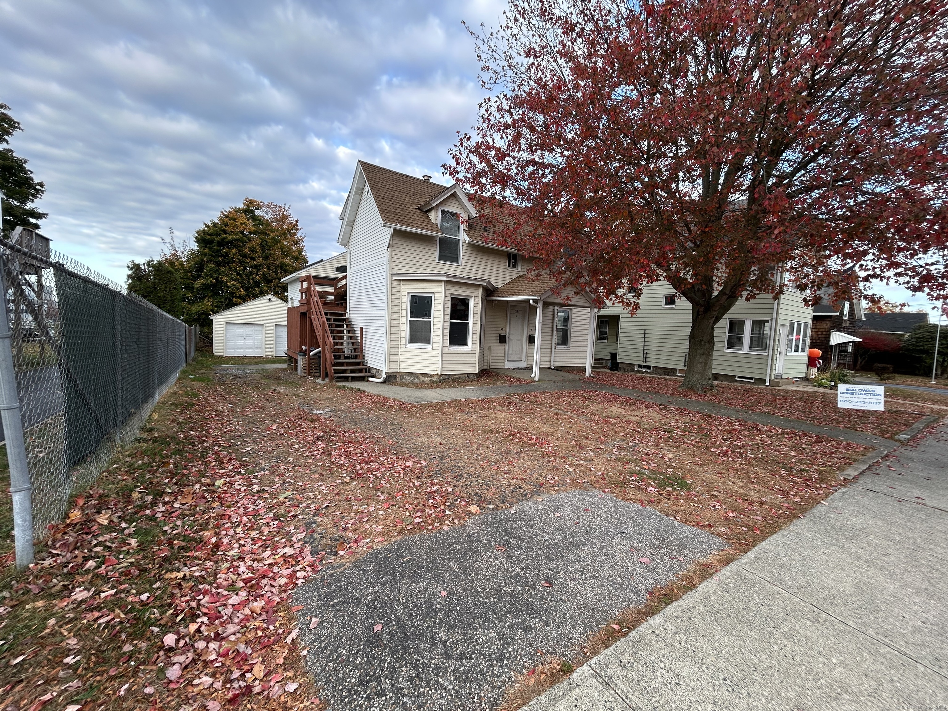 a front view of a house with a garden and trees