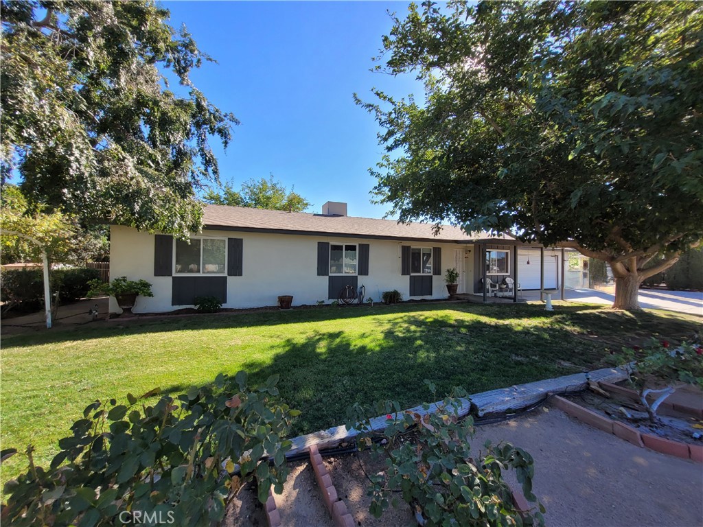 a front view of a house with a garden and trees