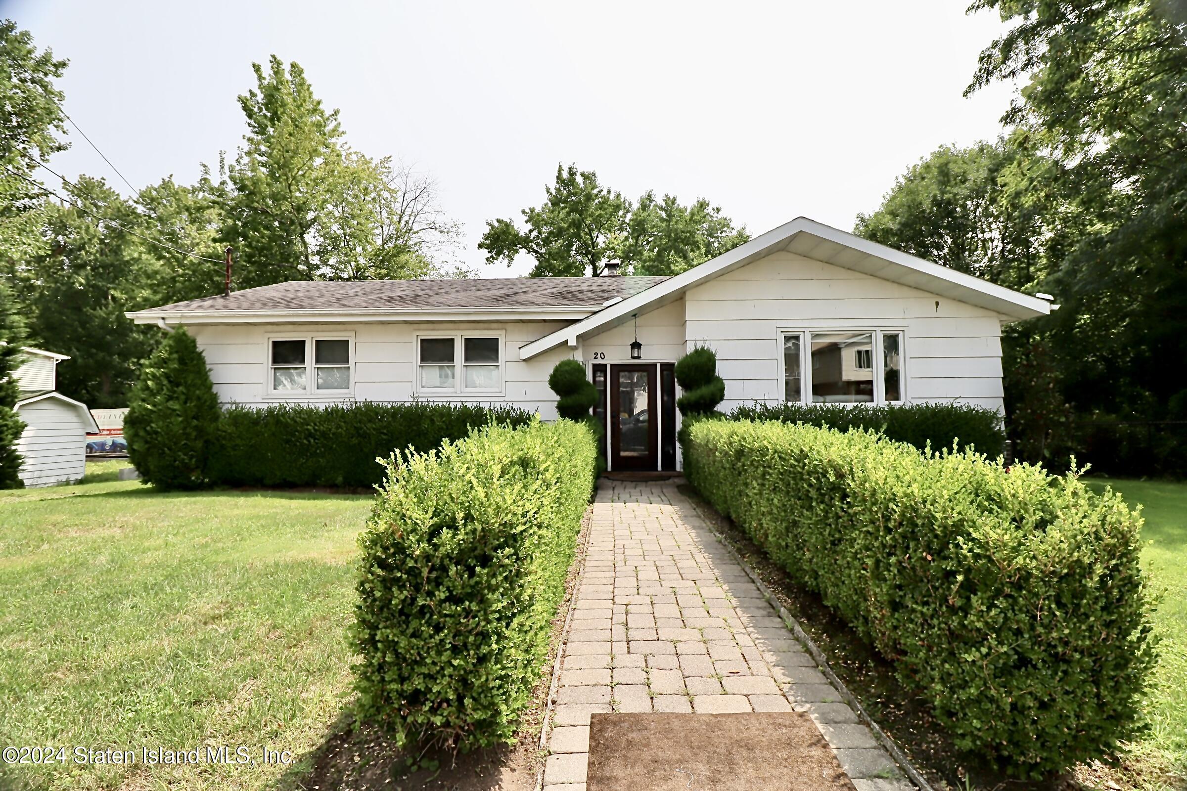 a view of a house with a yard and potted plants