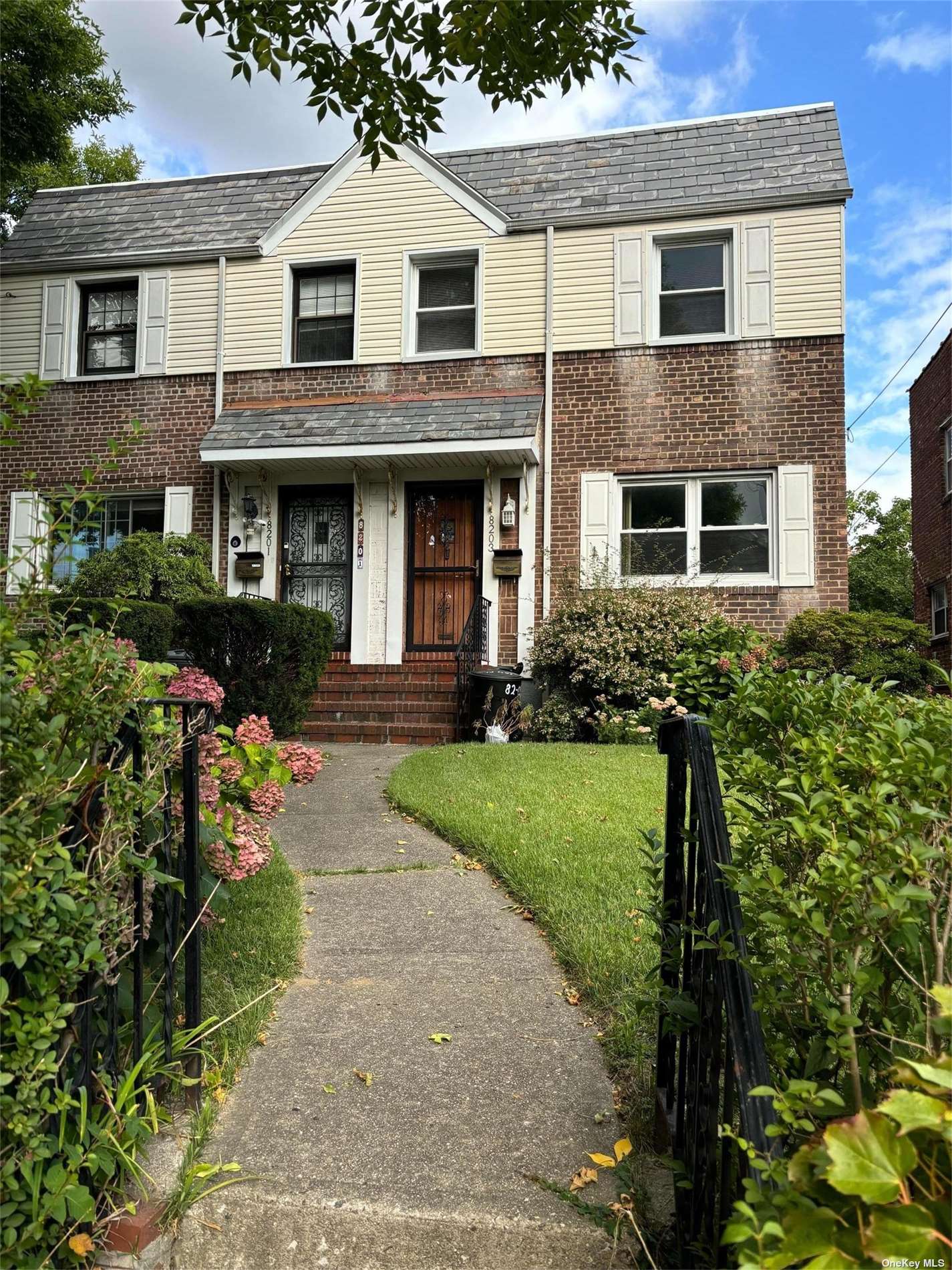 a front view of a house with a yard and potted plants