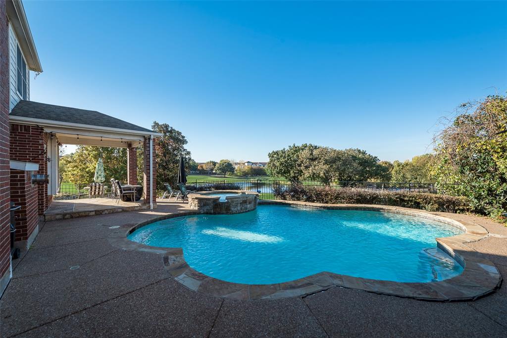 a view of a swimming pool with lawn chairs under an umbrella