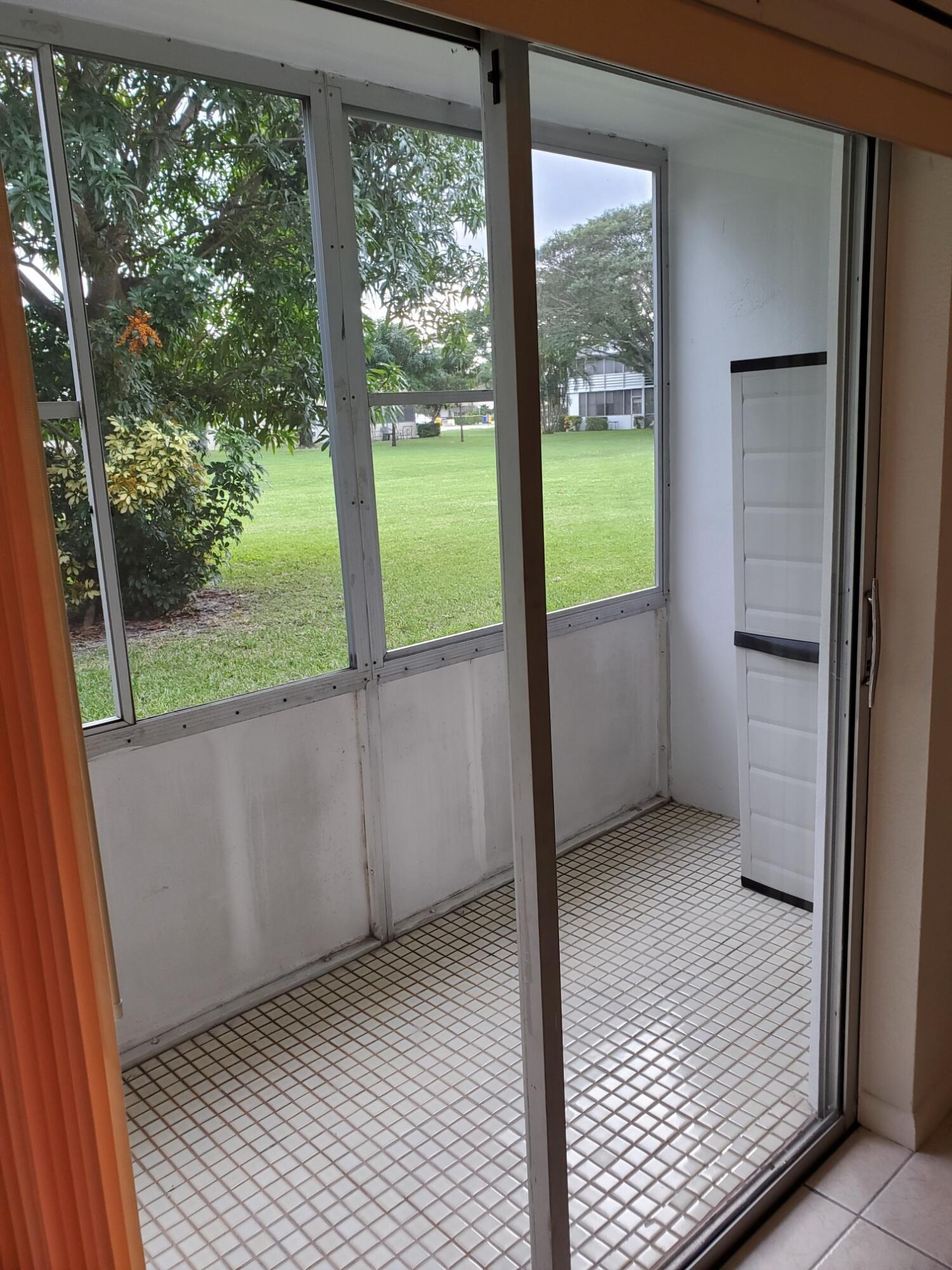 a view of an empty room with wooden floor and balcony