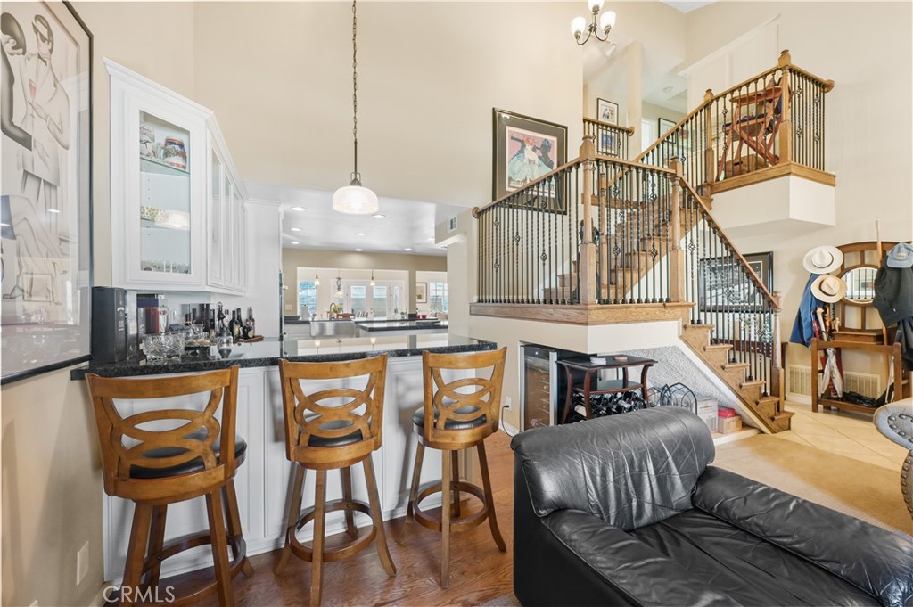 a view of a dining room and livingroom with furniture wooden floor a chandelier