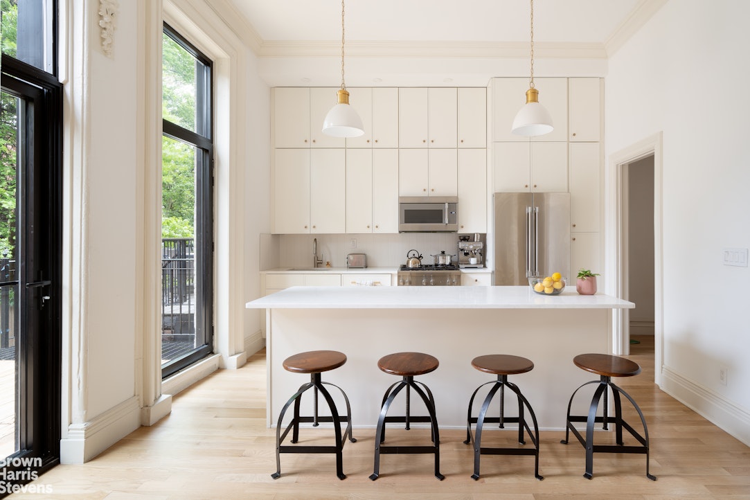 a kitchen with stainless steel appliances a table and chairs in it