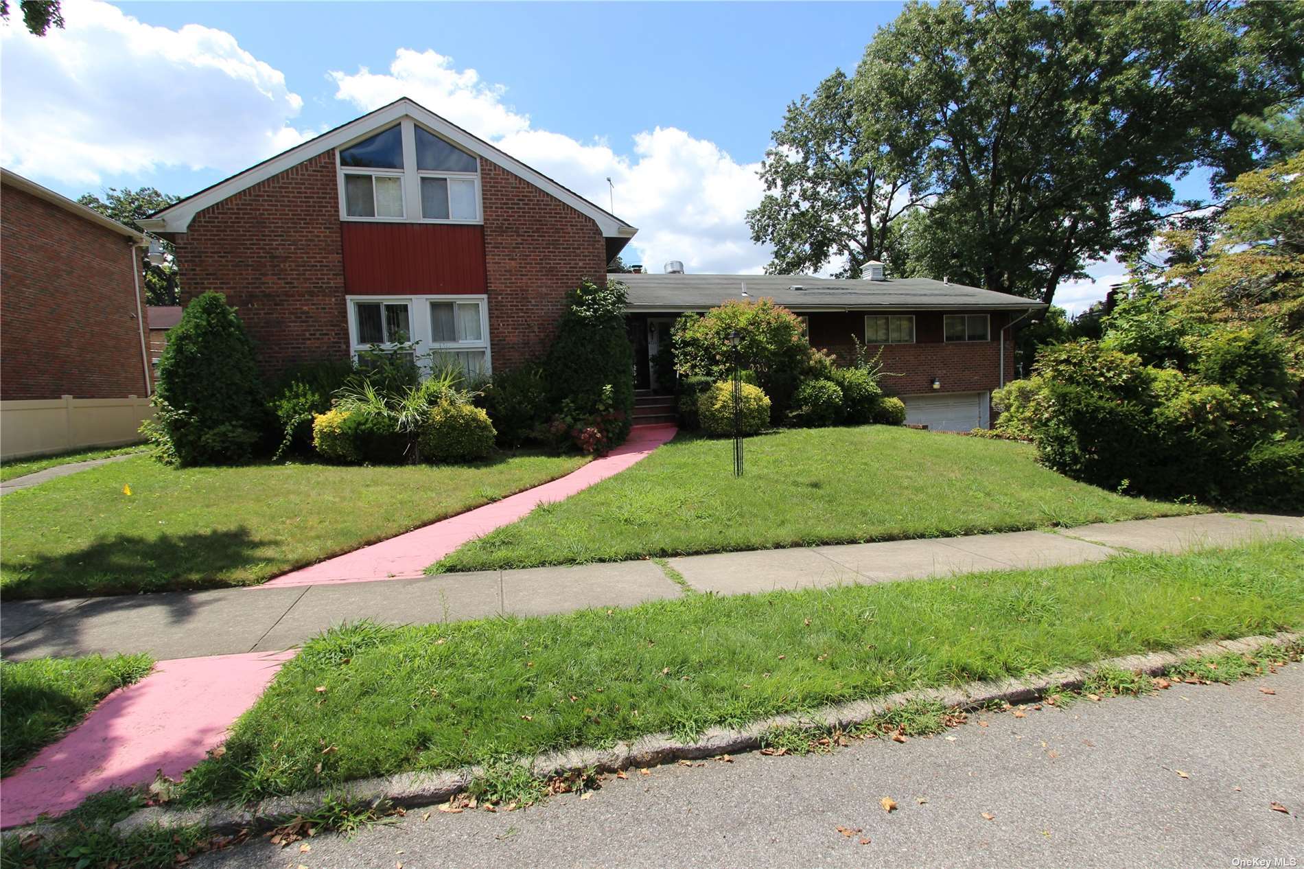 a front view of a house with a yard and potted plants