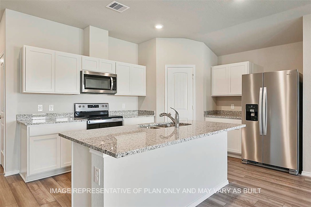 Kitchen with white cabinetry, light wood-type floo