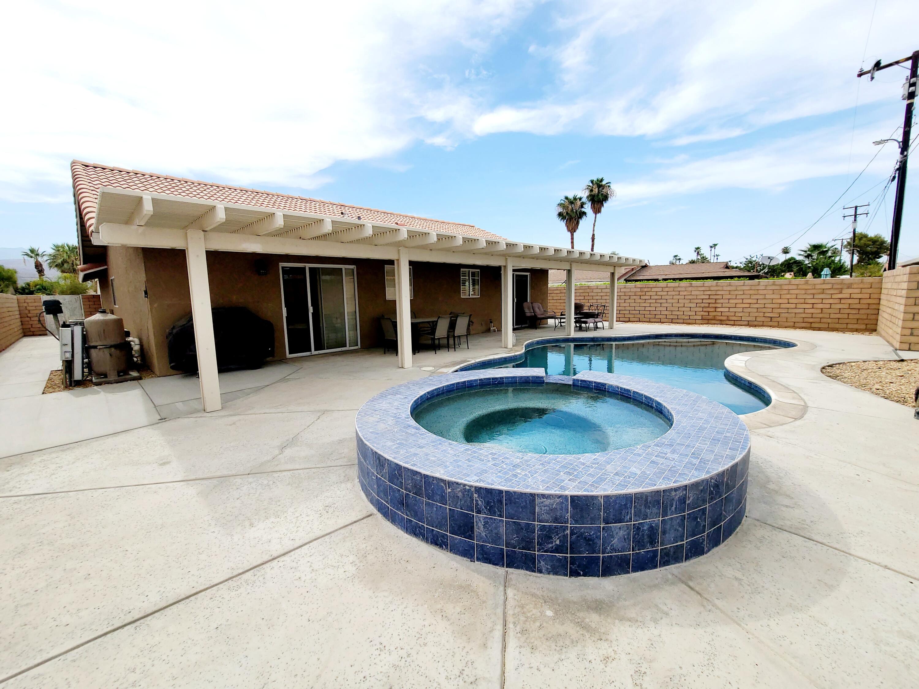 a view of a house with swimming pool and furniture