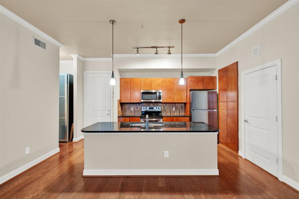 a kitchen with stainless steel appliances granite countertop a refrigerator a sink and a stove