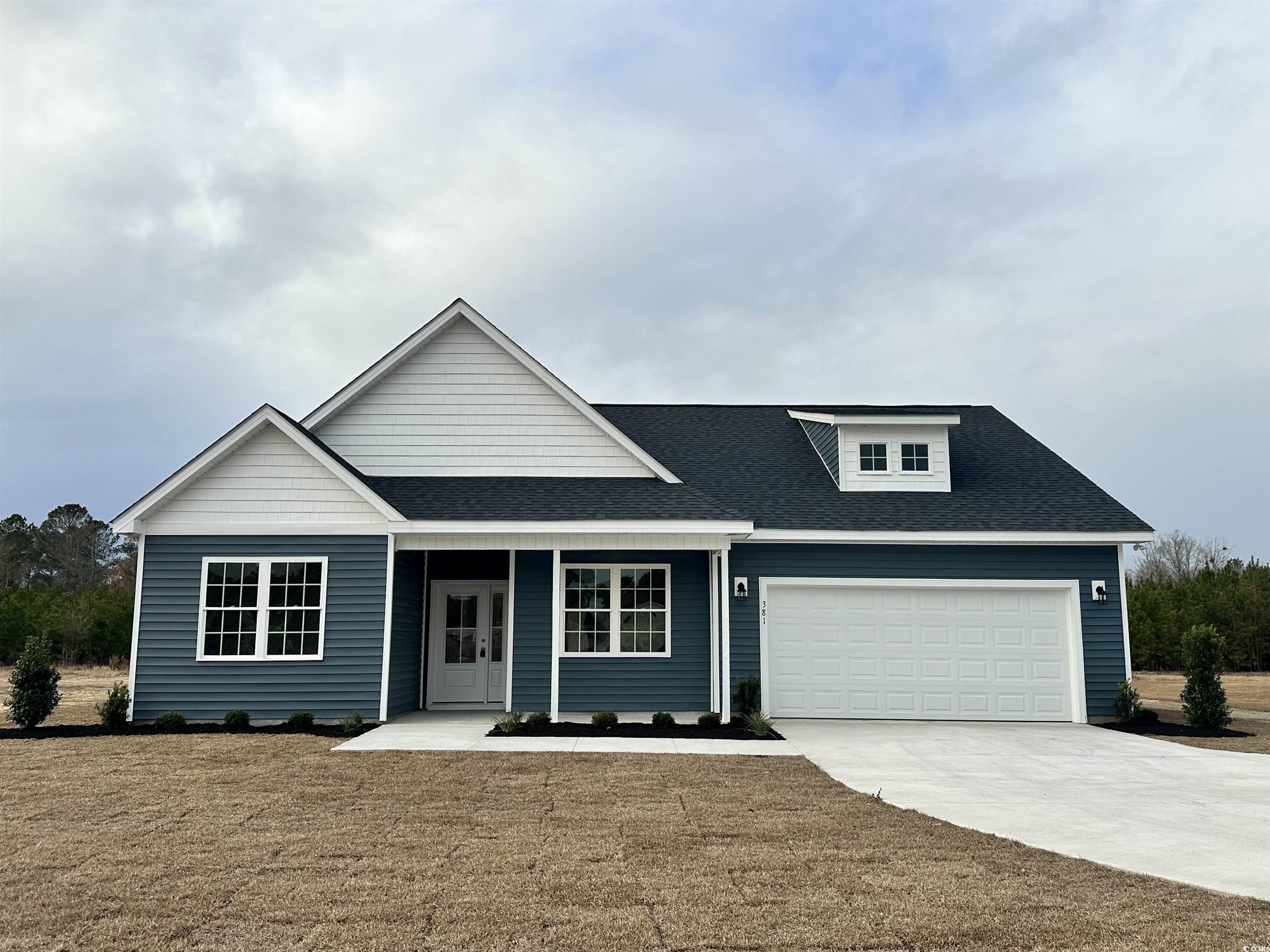 View of front of house with a front yard and a gar