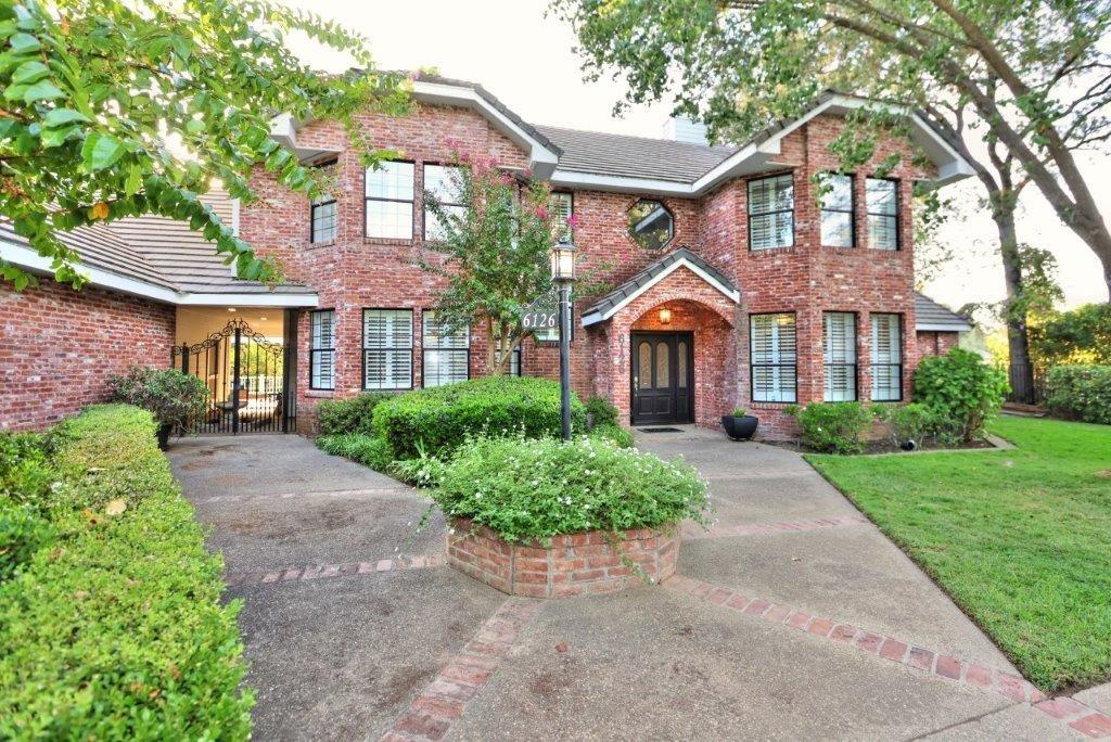 front view of a brick house with a yard