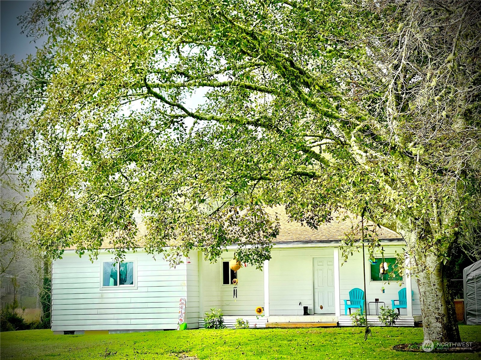 a front view of a house with a garden and trees