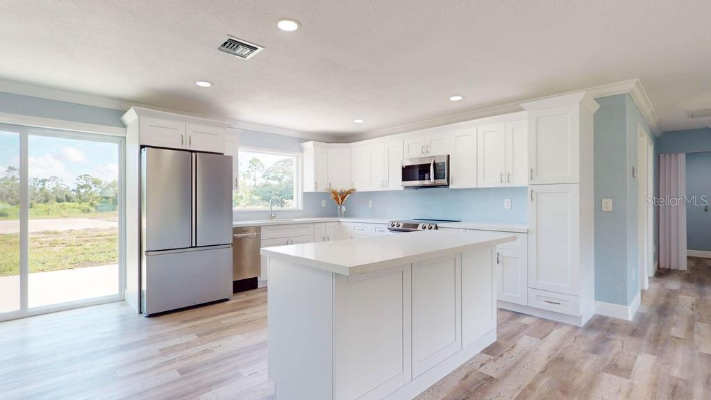 a kitchen with stainless steel appliances a refrigerator sink and microwave